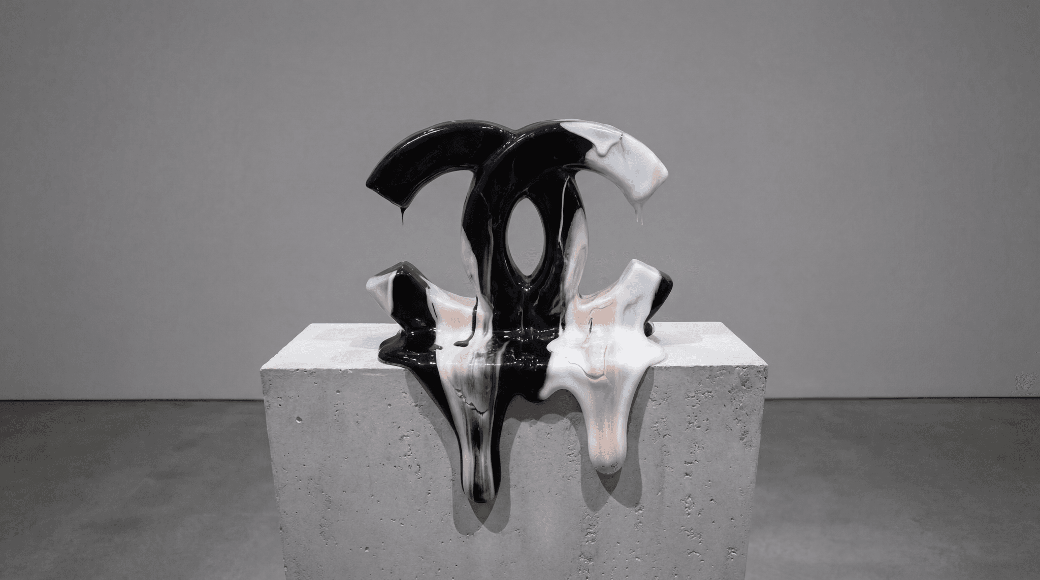 Sculpture Chanel CC fondante en porcelaine noire et blush sur socle béton dans une galerie